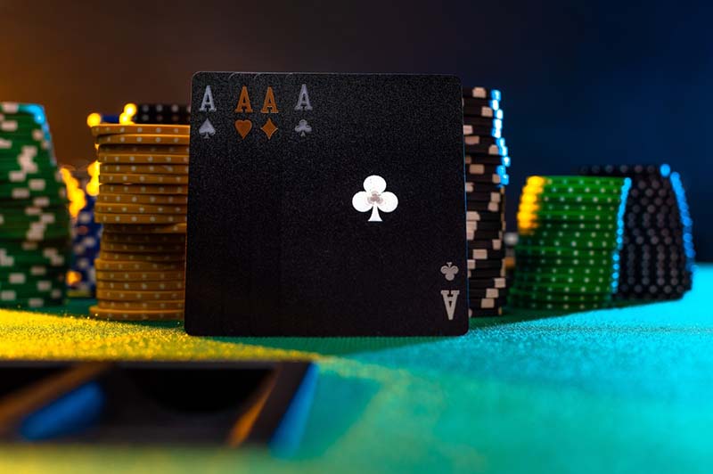 Crne poker karte i žetoni na zelenoj tkanini poker stola. Višebojna pozadina. kasino. Online kasino.