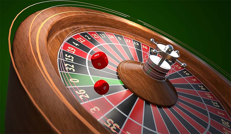 kotač ruleta kasina i crvene kockice kasina izolirane na zelenoj tamnoj