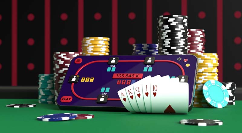 Online poker. Pametni telefon ili mobilni telefon, poker žetoni, karte na zelenom stolu u kasinu.